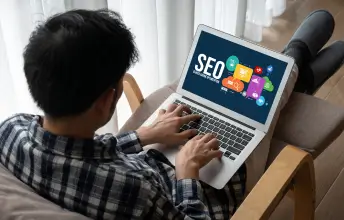 male looking at computer screen with seo written on it