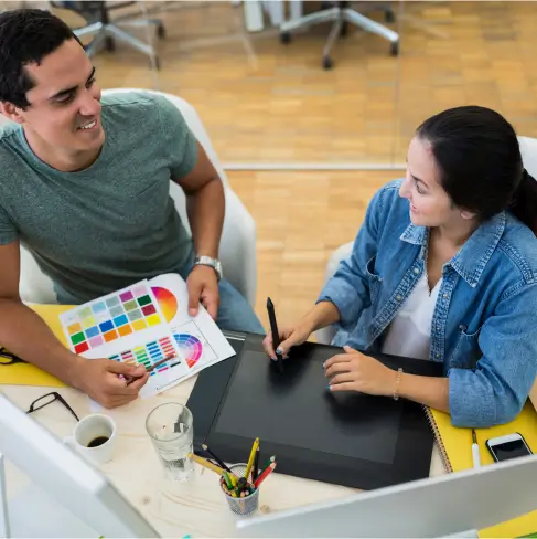 man and woman drawing on paper while looking at eachother