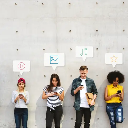 team-of-four-leaning-on-wall-and-using-their-phones